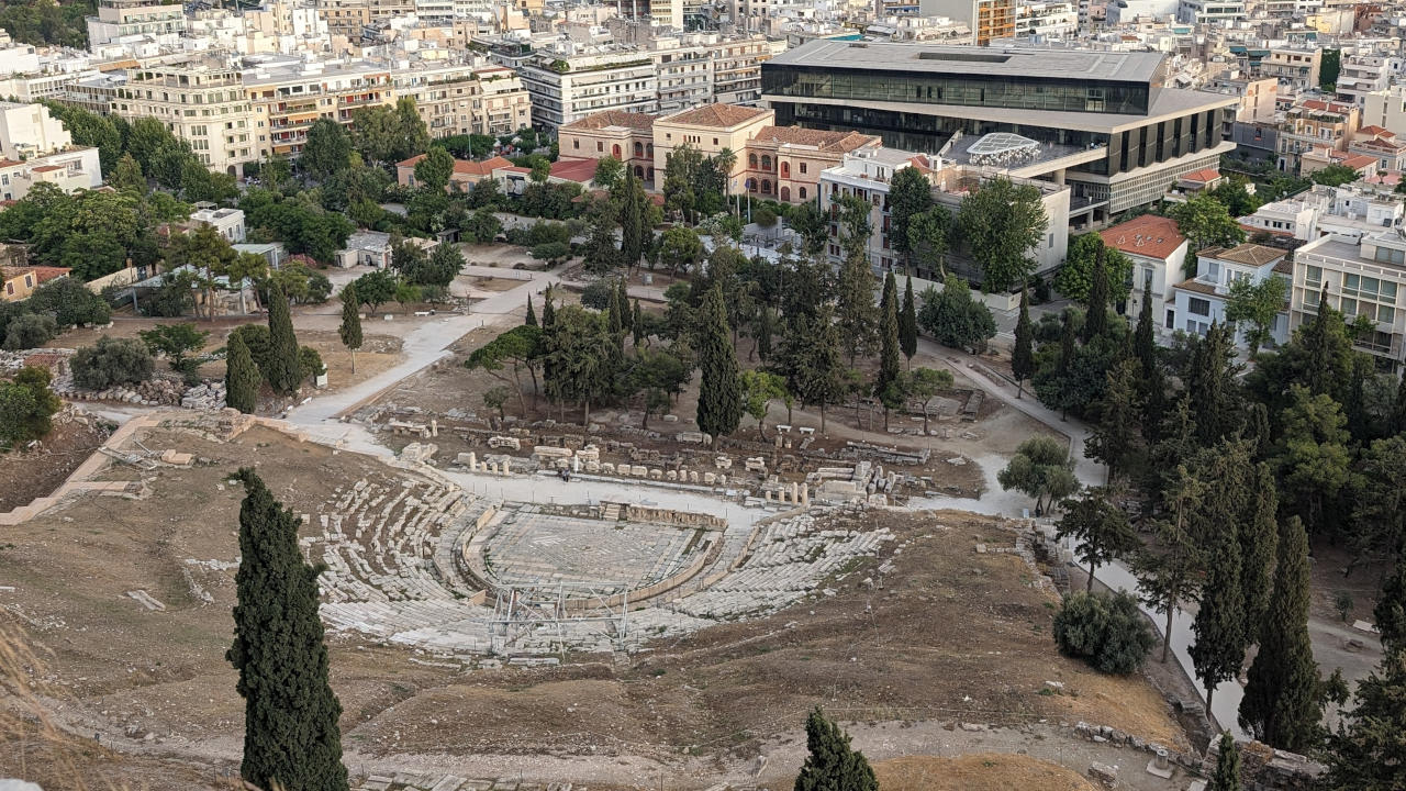 Antike trifft auf Moderne: Das Dionysostheater von oben von der Akropolis und im Hintergrund des Theaters das Akropolismuseum
