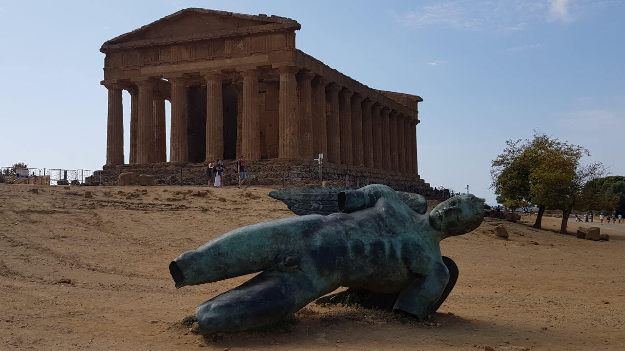 Nach Sizilien schaffte er es leider nie – Dennoch findet man im Tal der Tempel in Agrigent (Agrigento) in Sizilien vor dem Concordia-Tempel eine Skulptur des abgestürzten Ikarus. Die Bronzeskulptur liegt dort sei dem Jahr 2011 und stammt vom polnischen Bildhauers Igor Mitoraj (1942-2014) und soll tatsächlich den Sturz des Ikarus darstellen.
